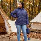HHE plus size women's lightweight packable quilted jacket in navy blue, warm and comfortable functional everyday wear, worn outdoors at a campsite.