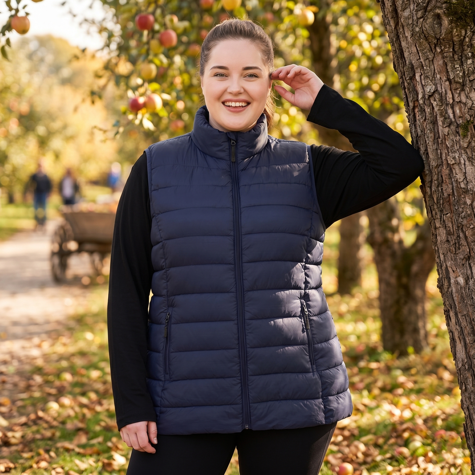 HHE plus size women's puffer vest in navy blue, warm and comfortable sleeveless outerwear, worn outdoors in a park.